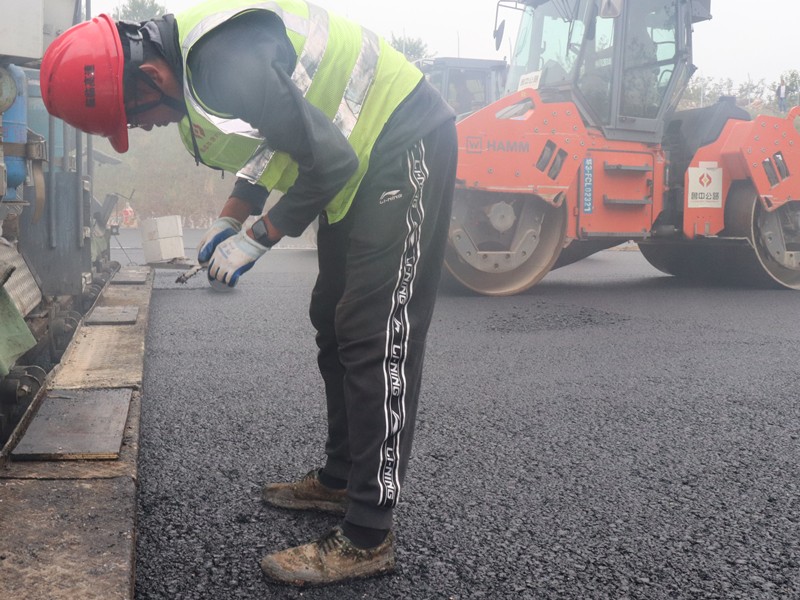 5、油層施工員任慶波隨時(shí)測(cè)量瀝青層松鋪厚度_副本